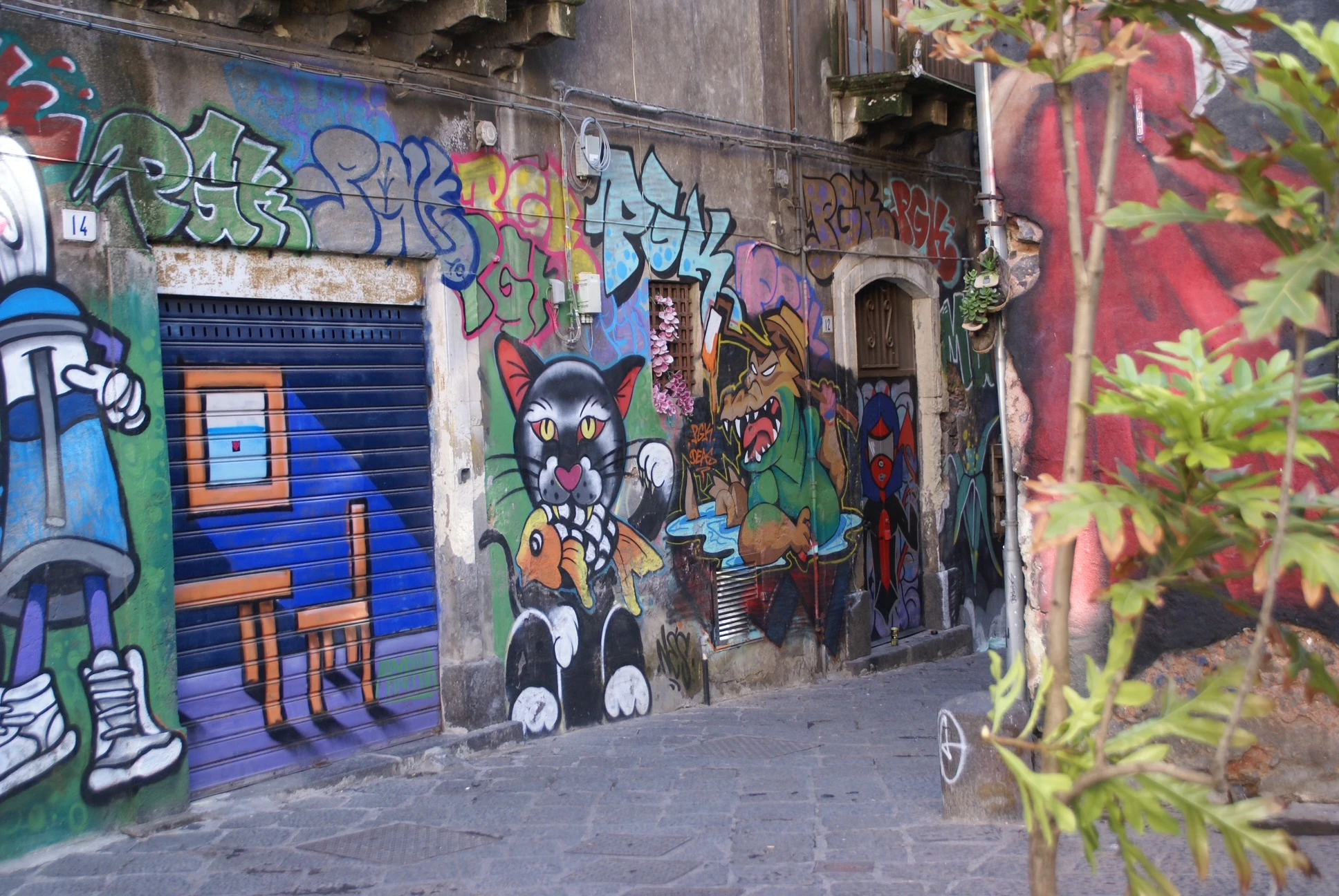 Street art Catania: murales colorati a San Berillo tra gatti cartoon, graffiti e simboli urbani